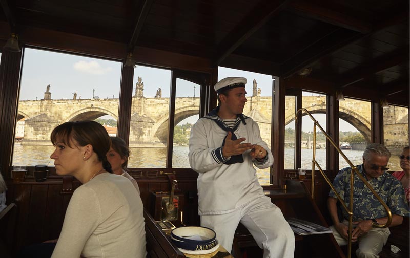 De kapitein vertelt op de boot over de historie van de Karelsbrug
